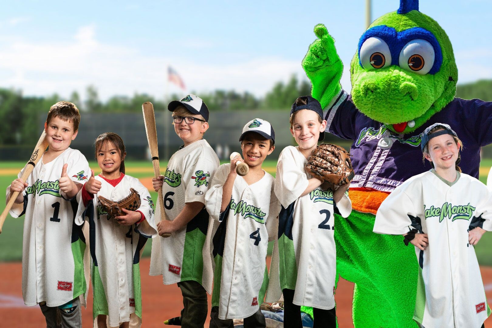 a group of kids in Lake Monster's uniforms with the Lake Monster's mascot