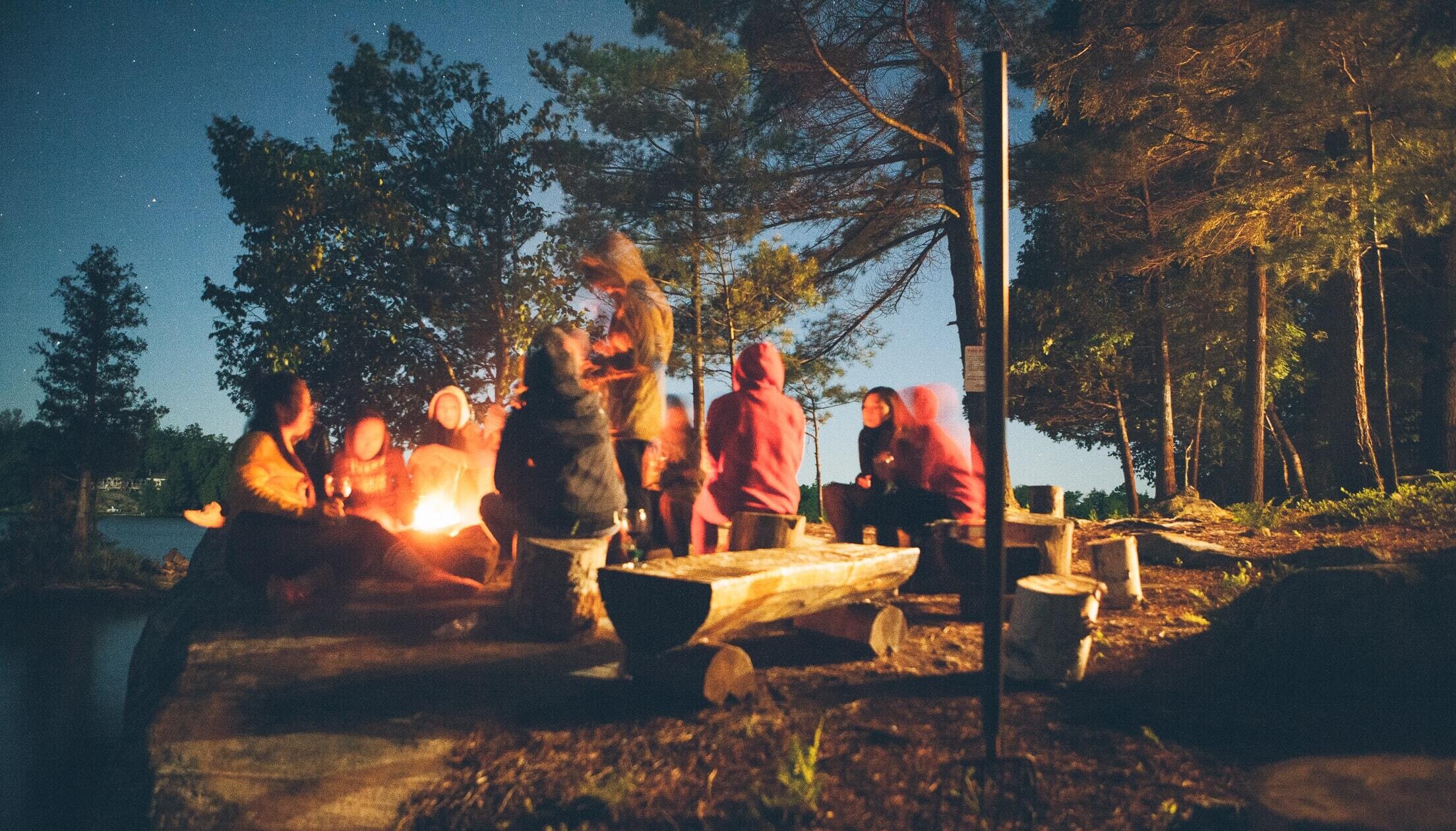 Community gathered around a campfire at dusk