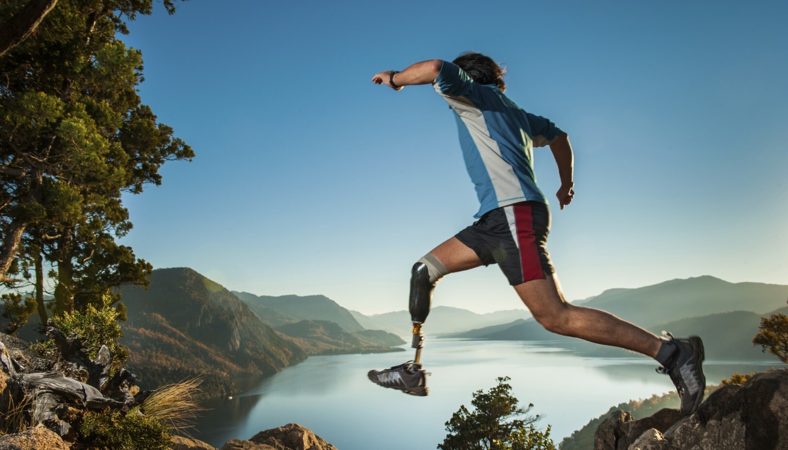 An athletic man with a prosthetic jumping while running